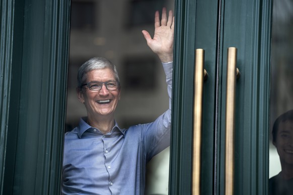 epa07562899 Apple CEO Tim Cook waves to customers in line at the newly refurbished Carnegie Library Apple Store in downtown Washington, DC, USA, 11 May 2019. Apple spent two years and an estimated $30 ...