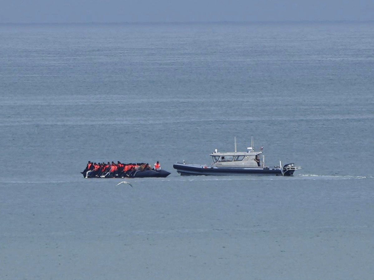 FILE - A boat thought to carry migrants is escorted by a vessel from the French Gendarmerie Nationale in the English Channel off Wimereux beach, France, Wednesday, Sept. 4, 2024. (AP Photo/Nicolas Gar ...