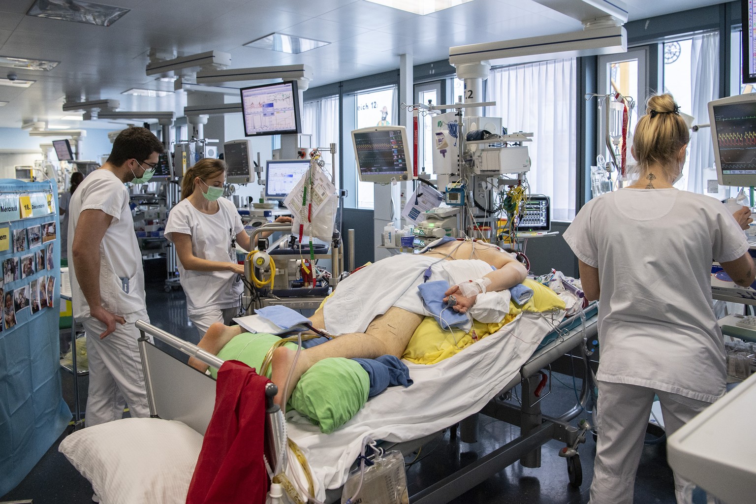 Pflegepersonal im Universitaetspital der Insel Gruppe kuemmern sich auf der Intensivstation um einen Covid Patienten , am Mittwoch, 16. Dezember 2020, in Bern. (KEYSTONE/Peter Schneider)