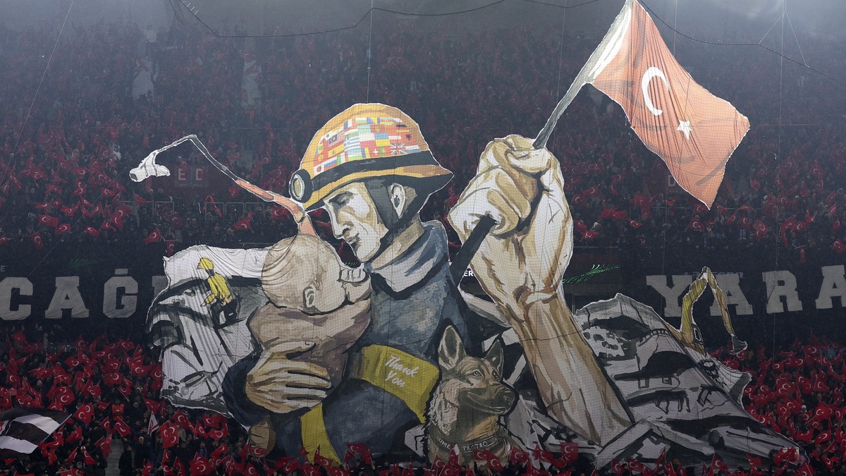 Fans show picture to honor of victims of earthquake in Turkey and Syria prior to the start of a Europa Conference League playoff first leg soccer match between Trabzonspor and Basel at the Senol Gunes ...