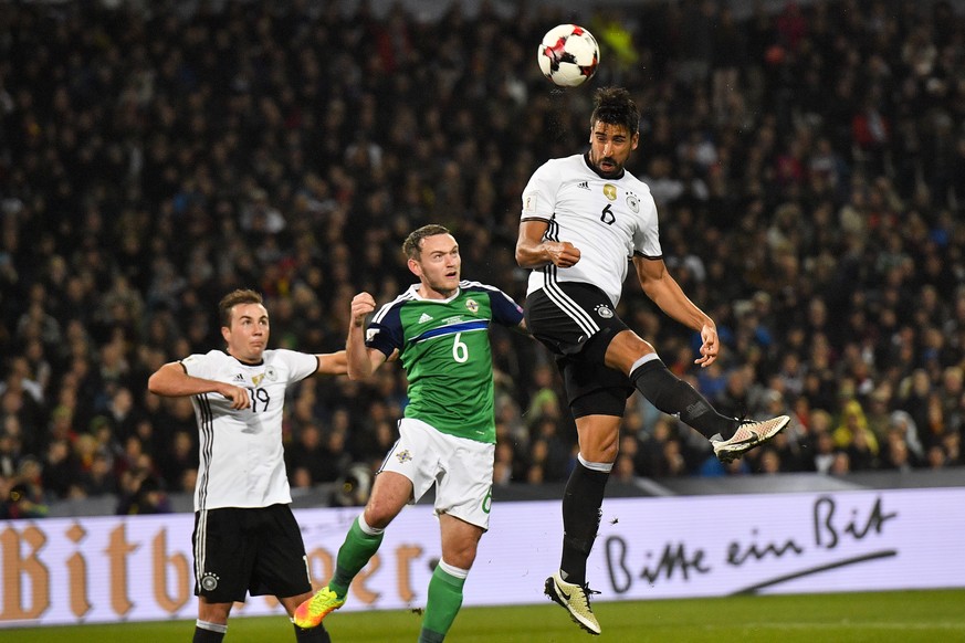 Germanys Sami Khedira, right, heads for the ball in front of Northern Irelands Lee Hodson, center, and Germanys Mario Goetze, left, during the World Cup Group C qualifying soccer match between Germ ...