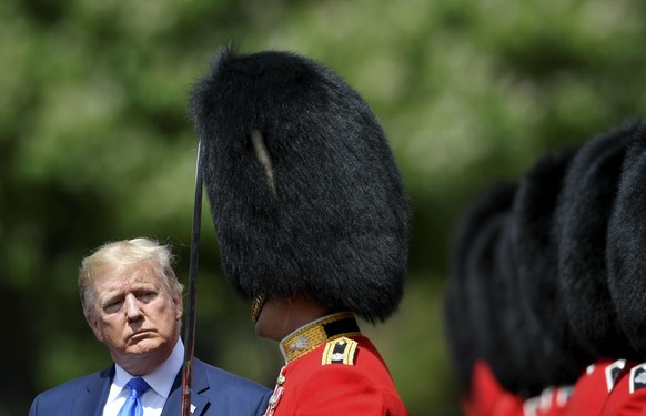 U.S President Donald Trump inspects an honour guard during a welcome ceremony in the garden of Buckingham Palace, in London, Monday, June 3, 2019, on the first day of a three day state visit to Britai ...