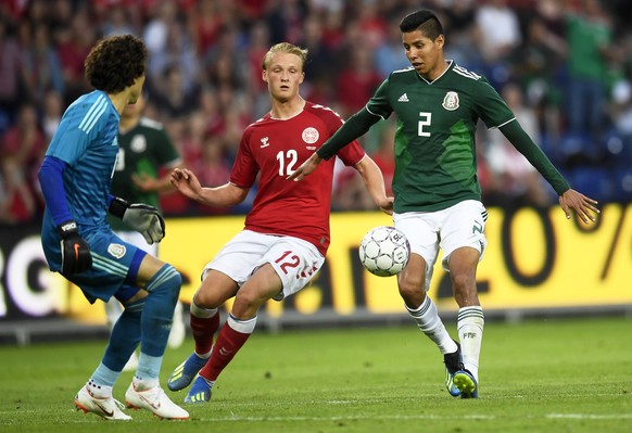epa06797593 Kasper Dolberg (C) of Denmark in action against Mexico&#039;s goalkeeper Guillermo Ochoa (L) and Hugo Ayala (R) during the International Friendly soccer match between Denmark and Mexico in ...