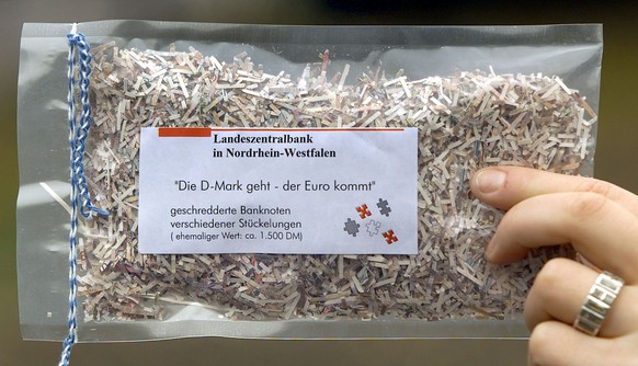 FILe -- An employee of the central bank of the western German state of North Rhine-Westphalia holds a bag with shreddered banknotes in Duesseldorf on in this Nov. 16, 2001 file picture. After the intr ...