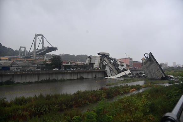 epa06948841 A large section of the Morandi viaduct upon which the A10 motorway runs collapsed in Genoa, Italy, 14 August 2018. Both sides of the highway fell. Around 10 vehicles are involved in the co ...