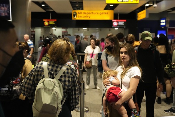 FILE - Travellers queue at security at Heathrow Airport in London, Wednesday, June 22, 2022. After two years of pandemic restrictions, travel demand is back with a vengeance but airlines and airports  ...