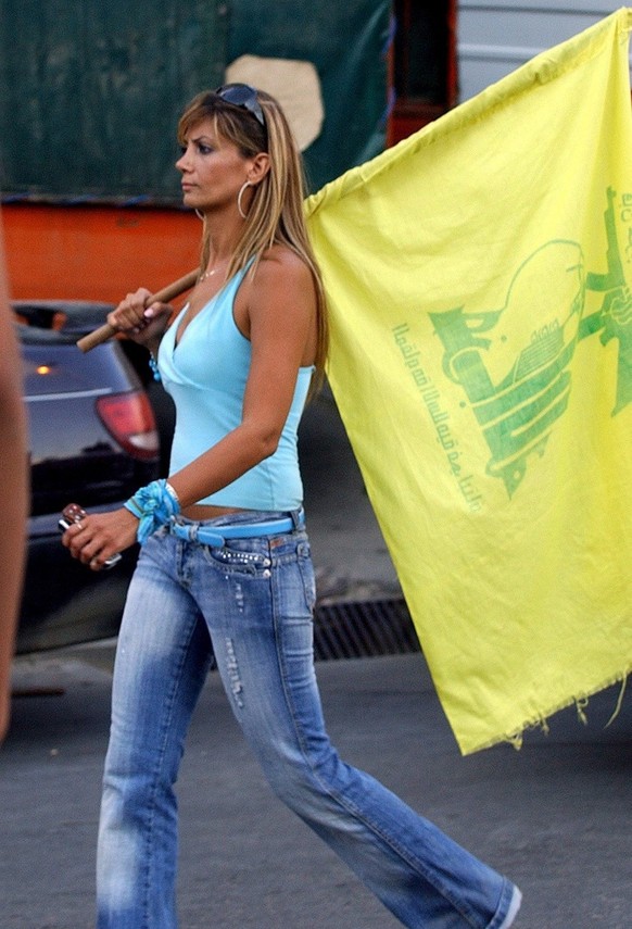 A Lebanese woman Hezbollah supporter carries a Hezbollah yellow flag during a Hezbollah &#039;victory over Israel&#039; rally, in Beirut&#039;s suburbs, Lebanon, Friday, 22 September 2006. Hundreds of ...