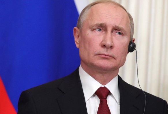 Russian President Vladimir Putin listens to a journalist&#039;s question during his and German Chancellor Angela Merkel joint news conference following their talks in the Kremlin in Moscow, Russia, Sa ...