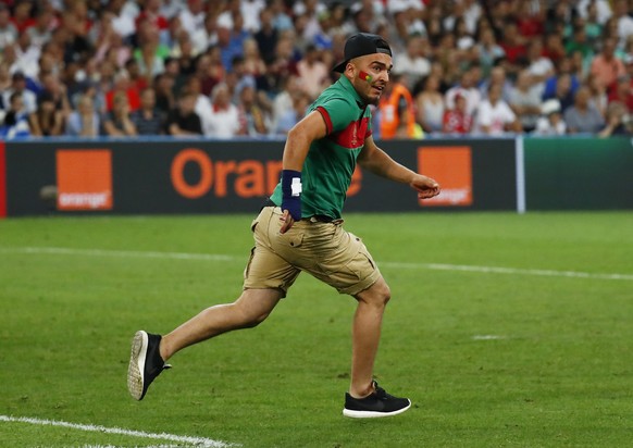 Sollte das witzig sein? Ein Zuschauer stürmt in der Verlängerung des EM-Viertelfinals zwischen Polen und Portugal auf den Rasen.