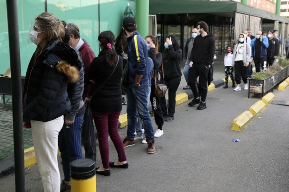 People line up to enter a supermarket, in Beirut, Lebanon, Monday, Jan. 11, 2021. Panic buyers swarmed supermarkets after reports the government planned to also order them shut in the tightened lockdo ...