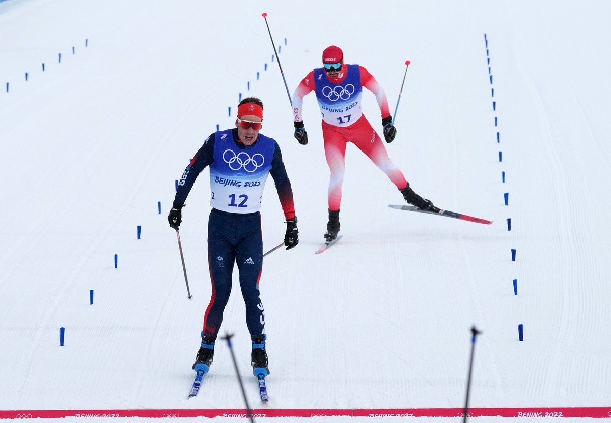 epa09770910 Andrew Musgrave (front) in the finish ahead of Dario Cologna of Switzerland in the Men's 50km Mass Start race at the Zhangjiakou National Cross-Country Skiing Centre at the Beijing 20 ...