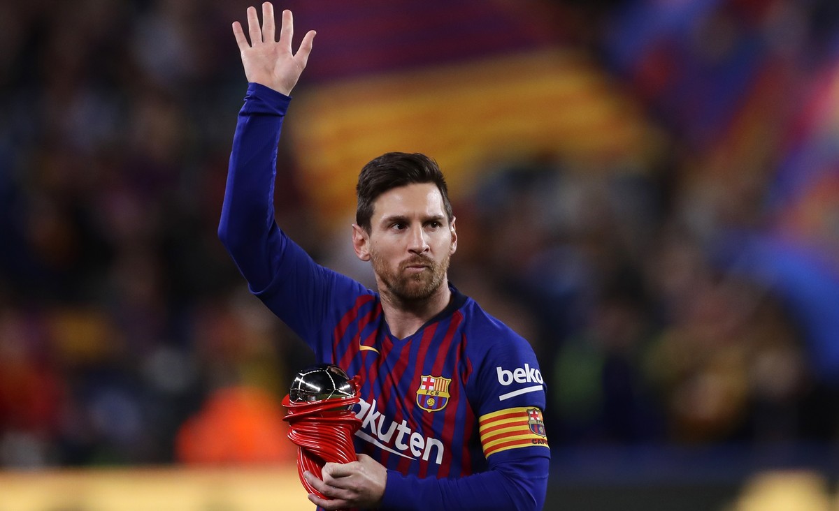 FILE - In this Saturday, April 6, 2019 file photo, Barcelona forward Lionel Messi waves at the crowd as he holds the trophy of the best Spanish La Liga player prior to a soccer match between FC Barcel ...