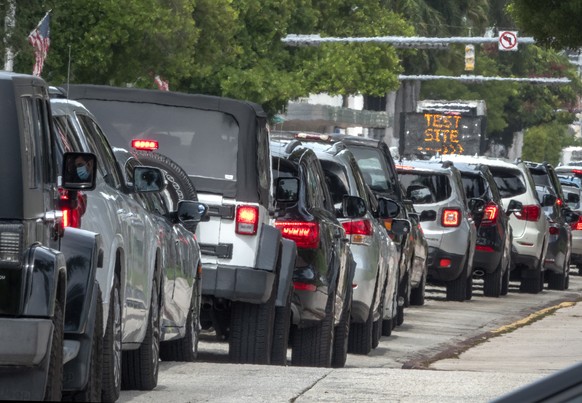 epa08552659 People queue in their cars to get the COVID-19 coronavirus testing service by the Florida Army National Guard partnered with the City of Miami Beach and the Florida Department of Health, a ...