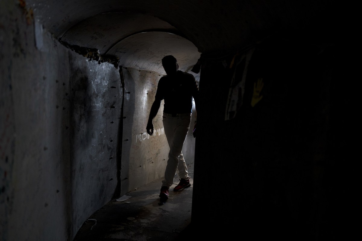 A visitor walks through a replica of a tunnel built by Hamas militants in the Gaza Strip, in a square in Tel Aviv, Israel that is a gathering point for families of hostages held by the militant group, ...