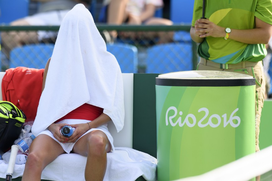 Timea Bacsinszky of Switzerland takes a breaks in a bath linen during the women&#039;s first round singles match against Shuai Zhang from China at the Olympic Tennis Center in Rio de Janeiro, Brazil,  ...