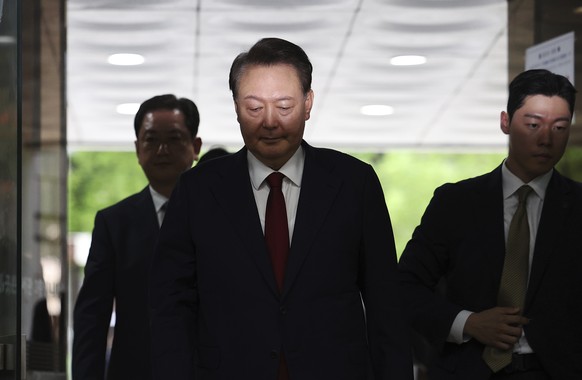 Former South Korean President Yoon Suk Yeol, centerm arrives at a court to attend a hearing to review his arrest warrant requested by special prosecutors in Seoul, South Korea Wednesday, July 9, 2025. ...