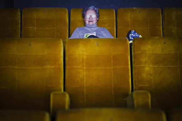 Eine Zuschauerin verfolgt einen Film im Kino Kosmos, am Donnerstag, 17. Februar 2022 in Zuerich. Der Bundesrat hebt per Donnerstag fast alle Corona-Massnahmen auf. Dazu gehoert auch die Maskenpflicht  ...