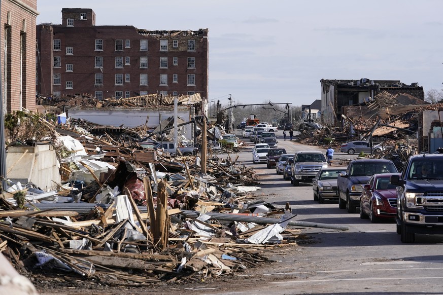 Automobiles line up near debris from tornado damage in Mayfield, Ky., on Saturday, Dec. 11, 2021. Tornadoes and severe weather caused catastrophic damage across multiple states Friday, killing multipl ...