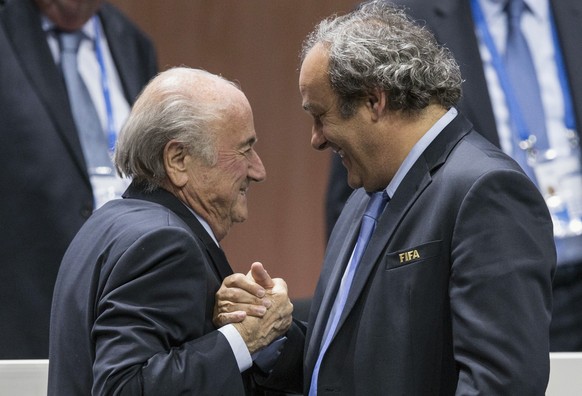 FILE - In this Friday, May 29, 2015 file photo, FIFA president Sepp Blatter after his election as President greeted by UEFA President Michel Platini, right, at the Hallenstadion in Zurich, Switzerland. Blatter has been re-elected as FIFA president for a fifth term, chosen to lead world soccer despite separate U.S. and Swiss criminal investigations into corruption. The 209 FIFA member federations gave the 79-year-old Blatter another four-year term on Friday after Prince Ali bin al-Hussein of Jordan conceded defeat after losing 133-73 in the first round.  (Patrick B. Kraemer/Keystone via AP, File)