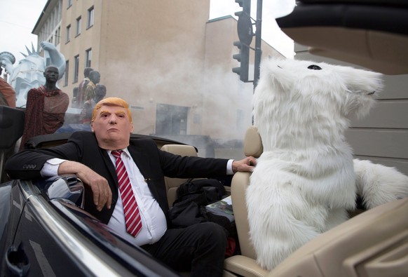 epa06307641 Protesters in costumes of a polar bear (R) and US President Donald J. Trump (L) sit in a convertible car at the &#039;Climate March&#039; demonstration prior to the UN Climate Change Confe ...