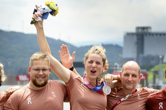 epa09372542 Silver medal winner Marlen Reusser (C) of Switzerland poses for photographer with her national coach Edi Telser (R) and her mechanic Cedric Staehli (L) after the victory ceremony of the Wo ...