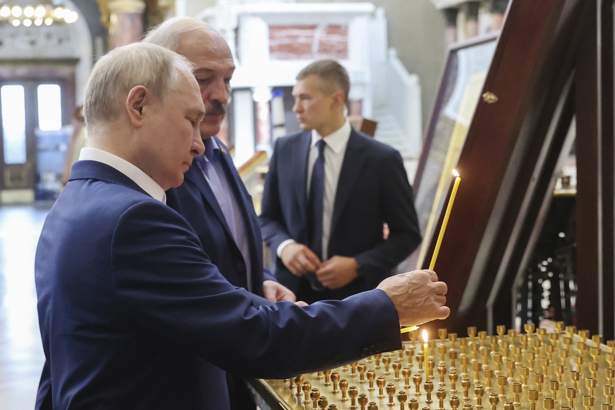 Russian President Vladimir Putin and Belarusian President Alexander Lukashenko light candles as they visit the Naval Cathedral of St. Nicholas, in Kronstadt, a seaport town in the suburb of St. Peters ...