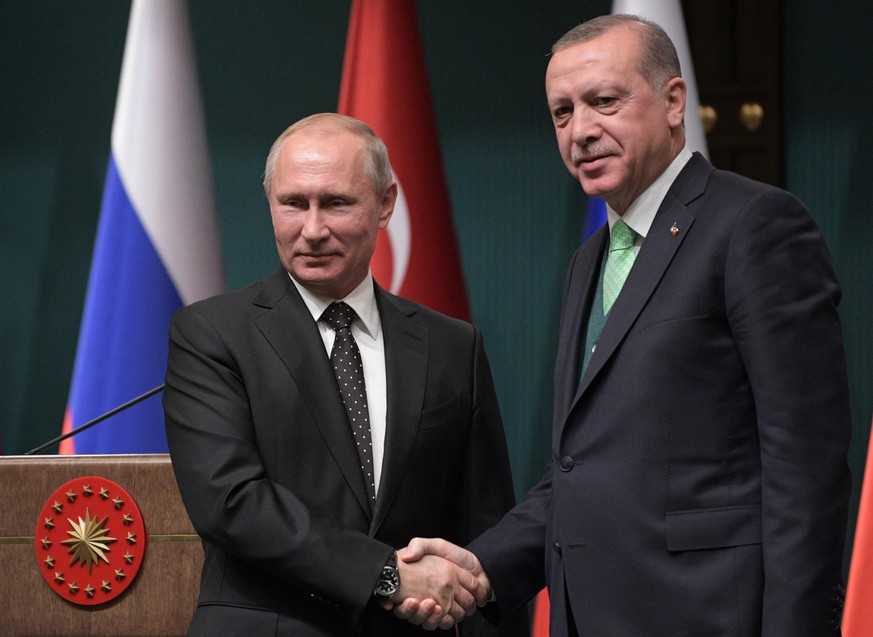 epa06383593 Russian President Vladimir Putin (L) shakes hands with Turkish President Recep Tayyip Erdogan (R) during their joint press statement following Russian-Turkish talks in Ankara, Turkey, 11 D ...