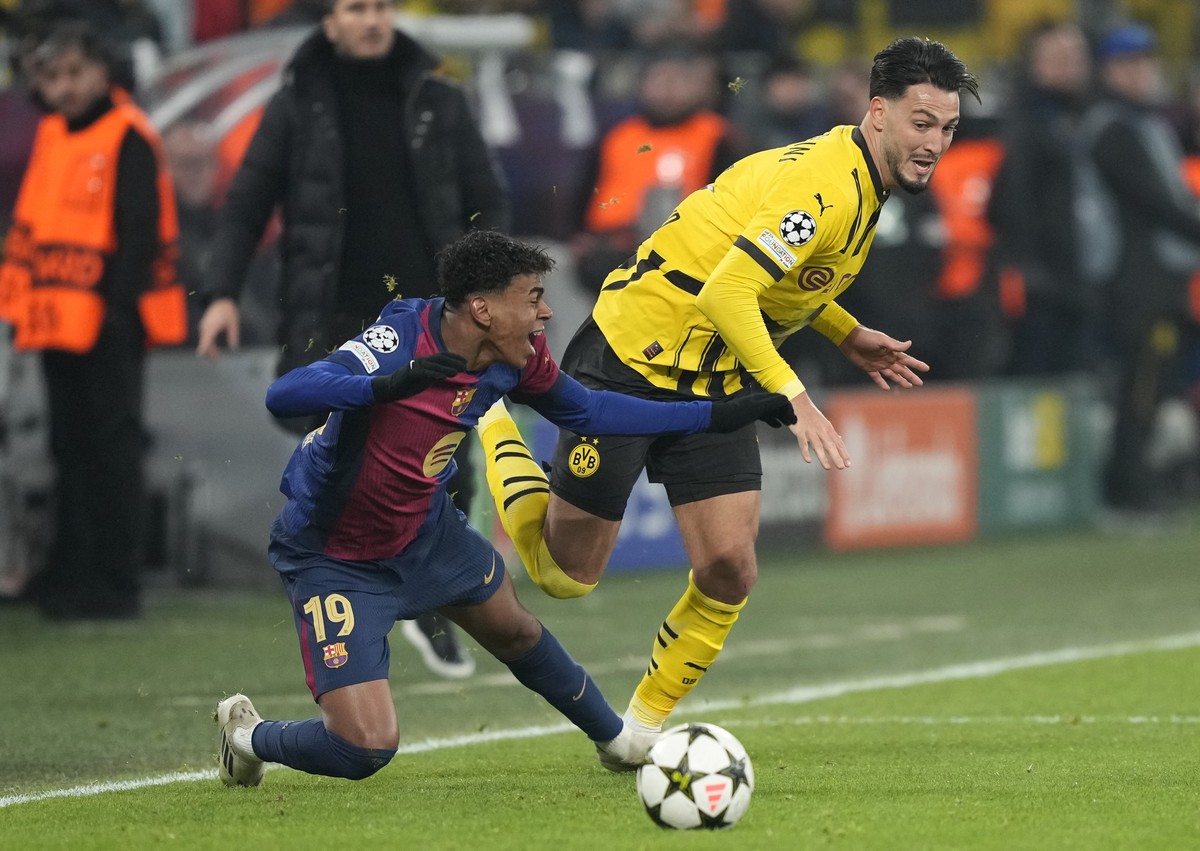 Barcelona's Lamine Yamal fights for the ball against Dortmund's Ramy Bensebaini during the Champions League opening phase soccer match between Borussia Dortmund and FC Barcelona at the Signa ...