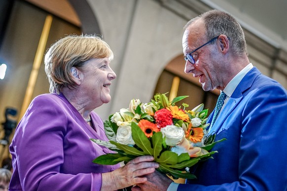 dpatopbilder - 25.09.2024, Berlin: Friedrich Merz, CDU-Bundesvorsitzender und Unionsfraktionsvorsitzender, �berreicht Angela Merkel beim Berliner Gespr�ch Spezial zum 70. Geburtstag der fr�heren Bunde ...