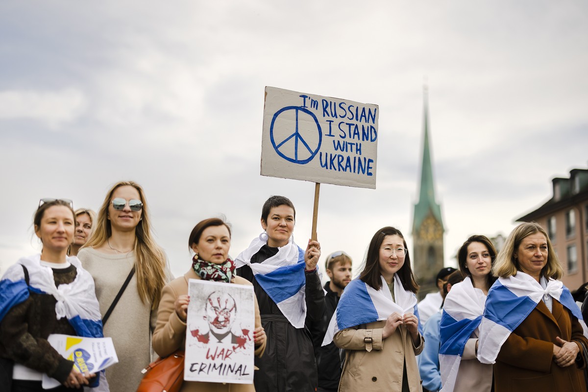 epa09926716 A woman holding a placard reading 'I'm Russian, I stand with Ukraine' takes part with others in a protest of Russians living in Switzerland against the Russian invasion of U ...