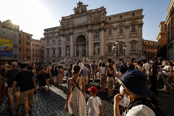 epa11488332 Tourists gather in front of Trevi fountain during a hot day in Rome, Italy, 19 July 2024. Temperatures are forecast to get as high as 40 degrees Celsius in areas of southern Italy at the w ...