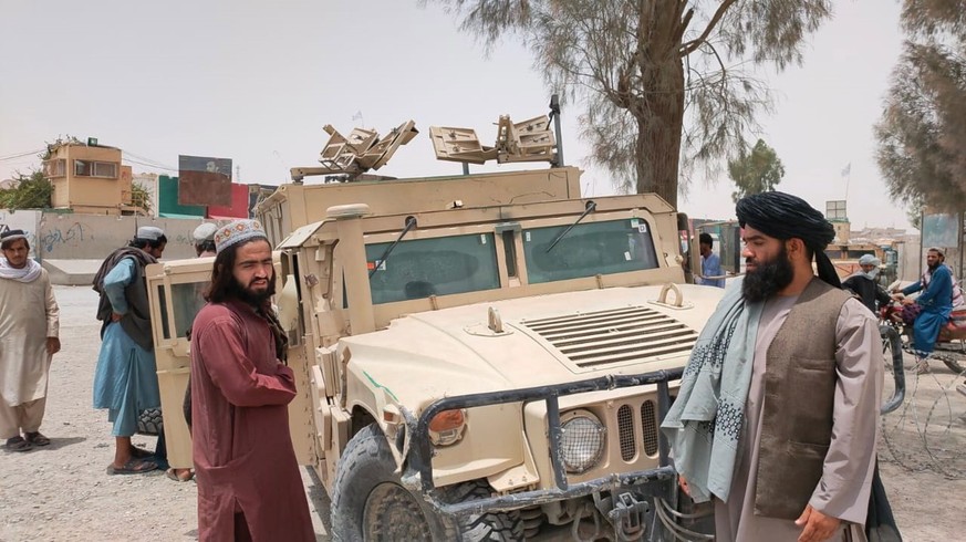 epa09350642 Afghan Taliban patrol in a humvee that was captured from Afghan security forces after Taliban took control of the Afghan side of the border, at Spin Boldak, Afghanistan, 17 July 2021. Tali ...