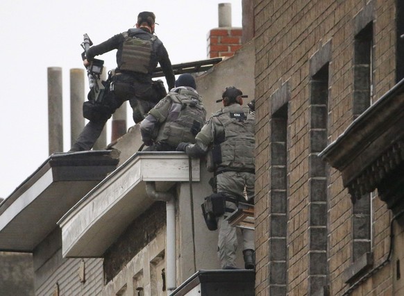Belgian special forces police climb high on an apartment block during a raid, in search of suspected muslim fundamentalists linked to the deadly attacks in Paris, in the Brussels suburb of Molenbeek,  ...