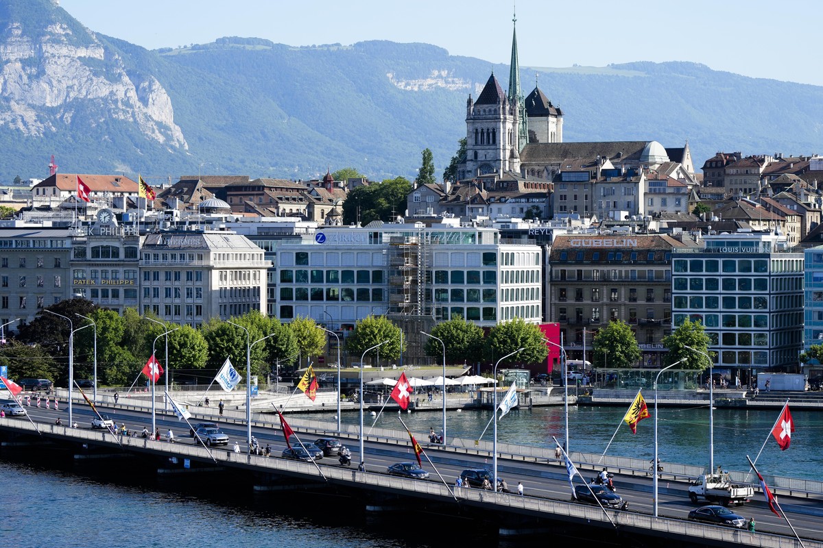 Cars drive on a bridge in front of the old town with the St. Pierre Cathedral in Geneva, Switzerland Monday, June 14, 2021. The lakeside city known as a Cold War crossroads and a hub for Swiss discret ...