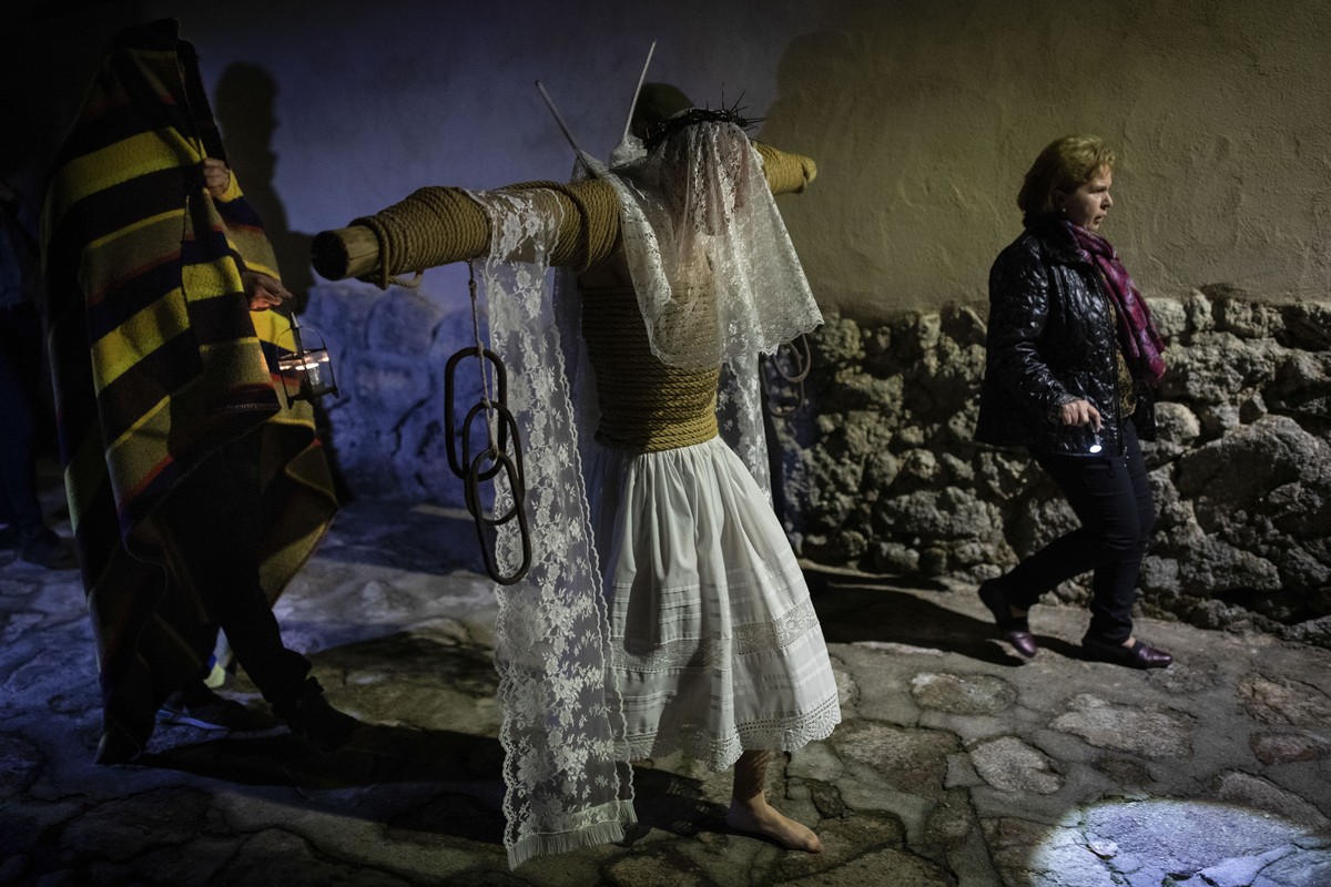 A penitent walks the Via Crucis' during the procession of 'Los Empalaos' in Valverde de la Vera, southwest Spain, early Friday, April 19, 2019. Hundreds of processions take place throug ...