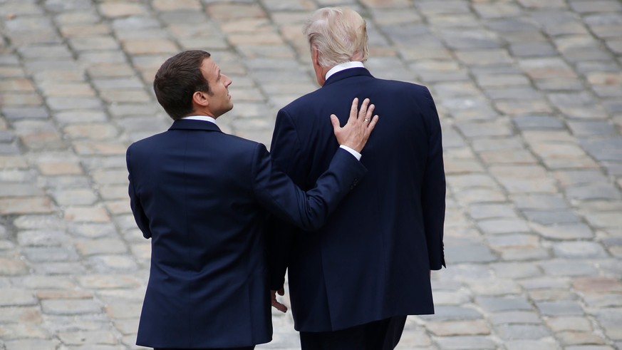 FILE - In this Thursday, July 13, 2017 file photo, French President Emmanuel Macron and US President Donald Trump , right, walk in the courtyard of the Invalides as part of an official welcoming cerem ...