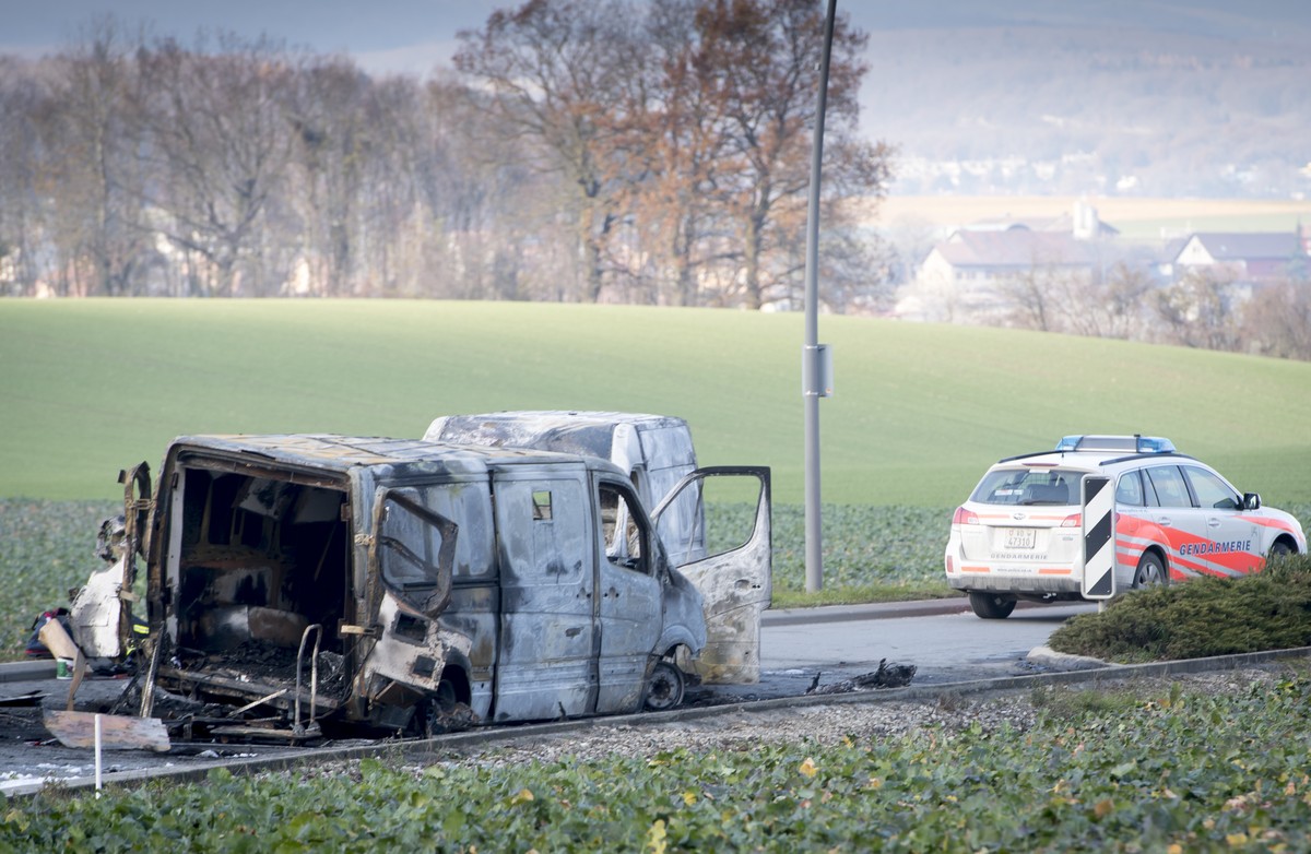 Une voiture de la police cantonale vaudoise stationnee a cote du fourgon de transport de fonds calcines a la sortie du village apres l'attaque d'un fourgon de transport de fonds ce mardi 3 d ...