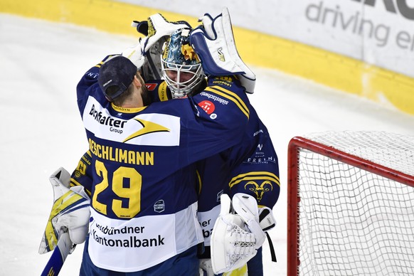 Der Davoser Ersatzgoli Sandro Aeschlimann, links, gratuliert Torhueter Gilles Senn zu seinem Shutout, im Eishockey-Qualifikationsspiel der National League zwischen dem HC Davos und dem Genf-Servette H ...