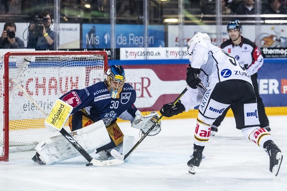 Zugs Torhueter Leonardo Genoni und Luganos Romain Loeffel, von links, beim Eishockey Meisterschaftsspiel der National League zwischen dem EV Zug und dem HC Lugano, am Samstag, 21. September 2019 in de ...