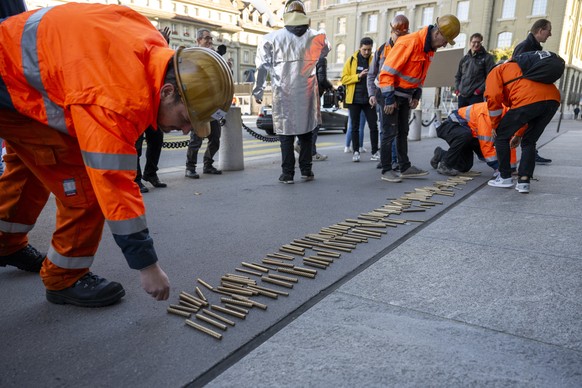 Mitarbeiter von Stahl Gerlafingen AG legen Stahlstaebe vor das Bundeshaus anlaesslich einer Kundgebung, am Montag, 21. Oktober 2024, in Bern. Die zur italienischen Beltrame Group hat Entlassungen von  ...