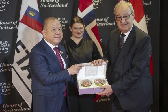 Thailand&#039;s Minister of Commerce Pichai, left, shake hands with Switzerland&#039;s Economy Minister Federal Councillor Guy Parmelin during the signing Ceremony of the Free Trade Agreement between  ...