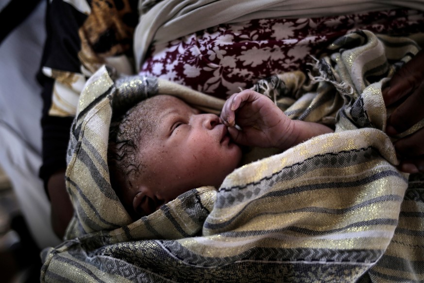 A new born baby girl lays in her mothers&#039; arms right after being born onboard a Spanish rescue vessel on the Mediterranean Sea, Wednesday, Sept. 6, 2017. A rescued woman from Ghana has given birt ...