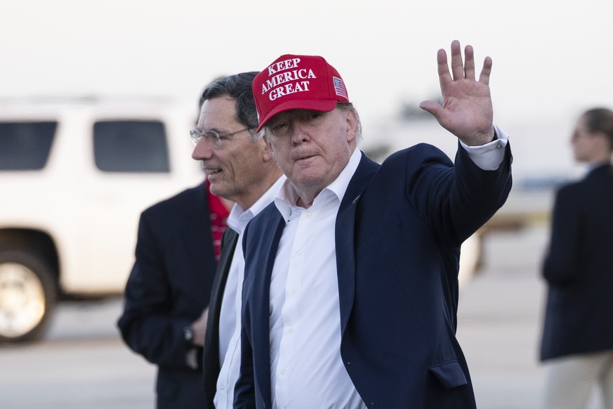 President Donald Trump waves as he steps off Air Force One, accompanied by Sen. John Barrasso, R-Wyo., left, at the Palm Beach International Airport, Friday, Nov. 29, 2019, in West Palm Beach, Fla. Tr ...