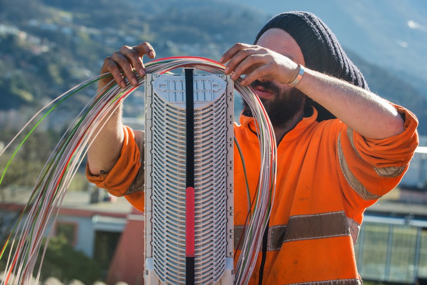 Ein Arbeiter montiert Glasfaserkabel der Swisscom fuer den Internetansschluss von Privathaushalten, am Dienstag, 10. Februar 2015 in Bellinzona. Die staedtischen Betriebe Bellinzona &quot;Aziende Muni ...