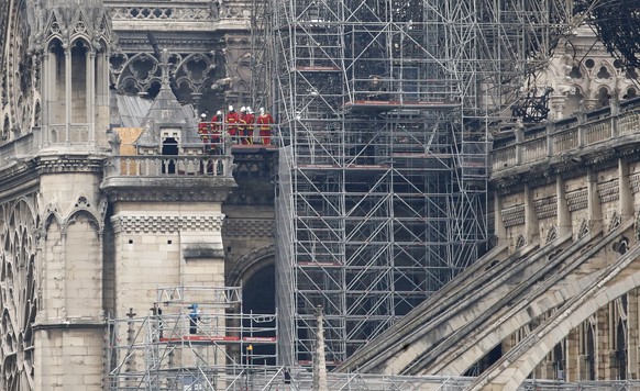 Firemen inspect the Notre Dame cathedral after the fire in Paris, Tuesday, April 16, 2019. Experts are assessing the blackened shell of Paris' iconic Notre Dame cathedral to establish next steps to save what remains after a devastating fire destroyed much of the almost 900-year-old building. With the fire that broke out Monday evening and quickly consumed the cathedral now under control, attention is turning to ensuring the structural integrity of the remaining building. (AP Photo/Christophe Ena)