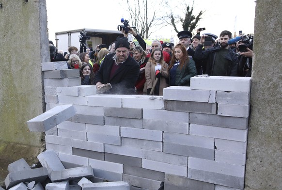 A demonstrator knocks down a &#039;mock&#039; wall on the Northern Ireland/Republic of Ireland border, near Newry in Northern Ireland, Saturday, Jan. 26, 2019. Protesters angered at the prospect of a  ...