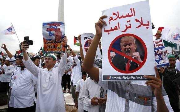epa06394627 Indonesian Muslim activists hold placards and shout slogans during a protest against US President Donald J.Trump&#039;s decision to recognize Jerusalem as capital of Israel at the National ...
