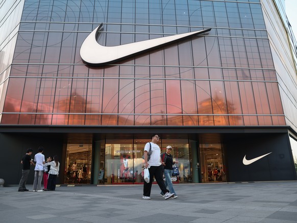 epa12099295 People walk past a Nike store in Beijing, China, 14 May 2025. After a tariff truce between the U.S. and China was agreed upon on 12 May, the U.S. will lower its maximum tariff rate on Chin ...