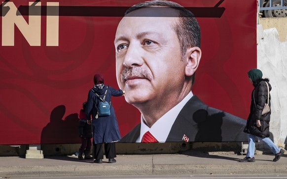 epa10413228 A woman shows to her child a picture of the Turkish President Recep Tayyip Erdogan in Istanbul, Turkey, 18 January 2023. President Erdogan announced that the presidential election could be ...