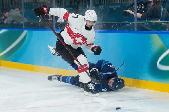 Switzerland's Jonas Siegenthaler (71) challenges for the puck Finland's Mikko Rantanen (96) during a men's ice hockey quarterfinal game between Finland and Switzerland at the 2026 Winte ...